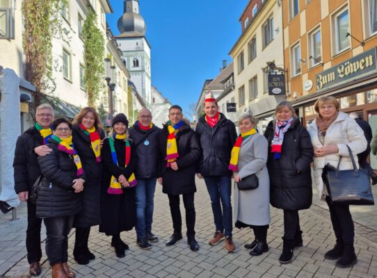 grupa uśmiechniętych ludzi w kolorowych szalikach