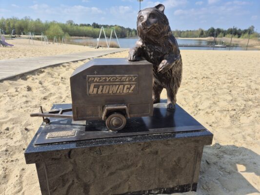 Rzeźba Rawickiego Niedźwiadka z brązu z przyczepą firmy Głowacz